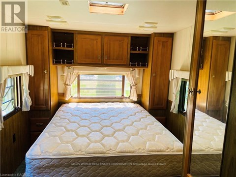 A bedroom with a large bed and wooden cabinets.
