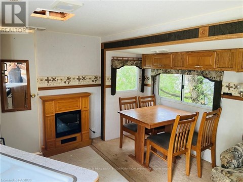 A living room with a fireplace and a dining table.