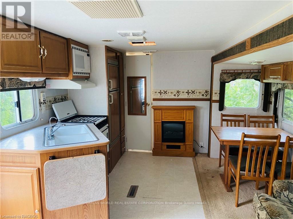 A kitchen area with a sink, microwave, and a refrigerator.