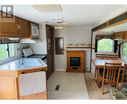 A kitchen area with a sink, microwave, and a refrigerator.