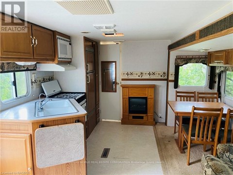 A kitchen area with a sink, microwave, and a refrigerator.