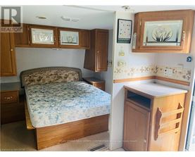A bedroom with a bed, a cabinet, and a counter.