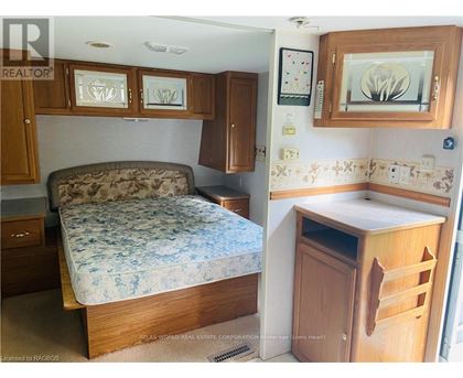 A bedroom with a bed, a cabinet, and a counter.