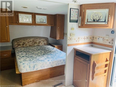 A bedroom with a bed, a cabinet, and a counter.