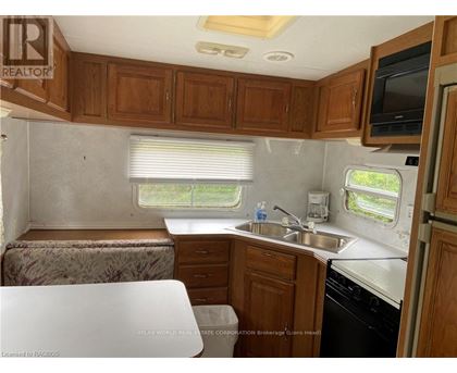A kitchen area with wooden cabinets and a white countertop.