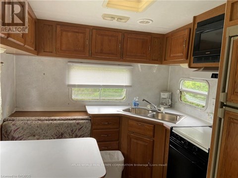 A kitchen area with wooden cabinets and a white countertop.