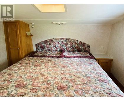 A bedroom with a floral bedspread and a wooden door.