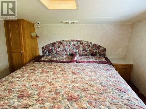 A bedroom with a floral bedspread and a wooden door.