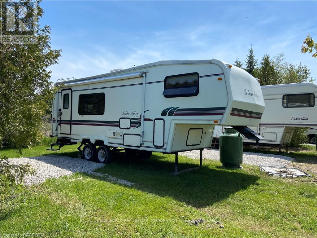 A white RV is parked in a grassy area.