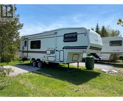 A white RV is parked in a grassy area.