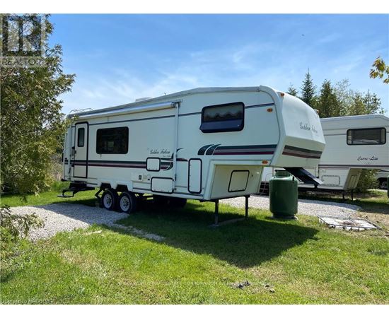 A white RV is parked in a grassy area.