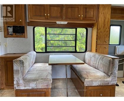 A living room with a couch and a table in front of a window.