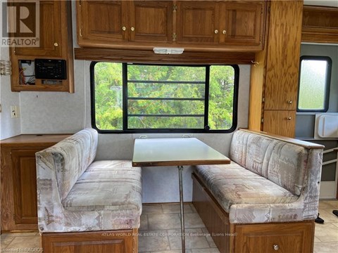 A living room with a couch and a table in front of a window.