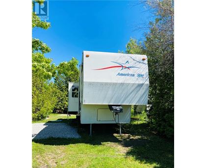 An American Star RV is parked in a grassy area.