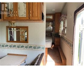 A view of a bedroom with a bed, dresser, and mirror.