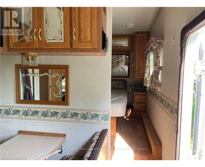 A view of a bedroom with a bed, dresser, and mirror.