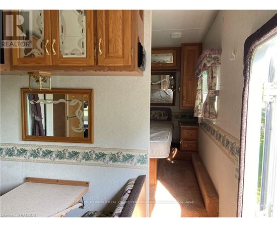 A view of a bedroom with a bed, dresser, and mirror.