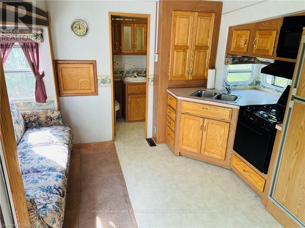 A kitchen with wooden cabinets and a stove top oven.
