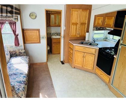 A kitchen with wooden cabinets and a stove top oven.