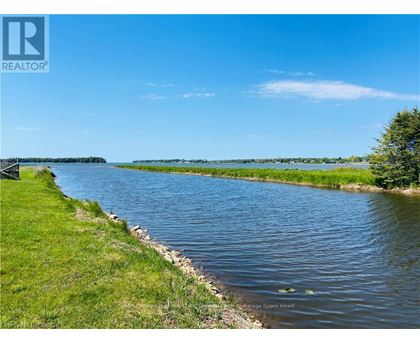 A river flows through a grassy area with a clear blue sky above.