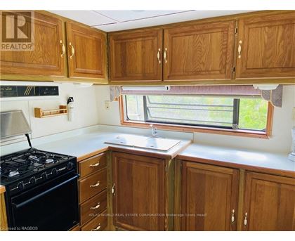 A kitchen with wooden cabinets and a black stove.
