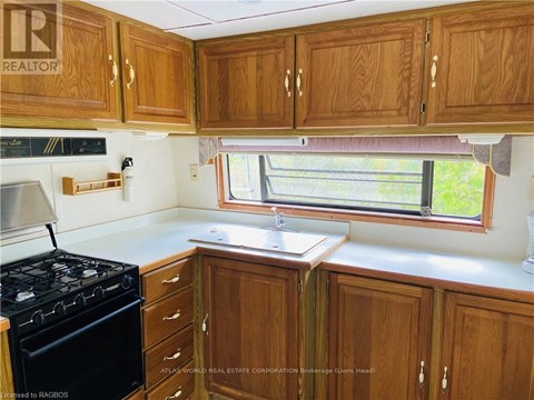 A kitchen with wooden cabinets and a black stove.