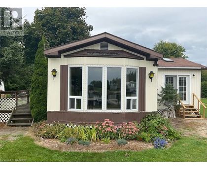 A small house with a brown roof and a garden in front.