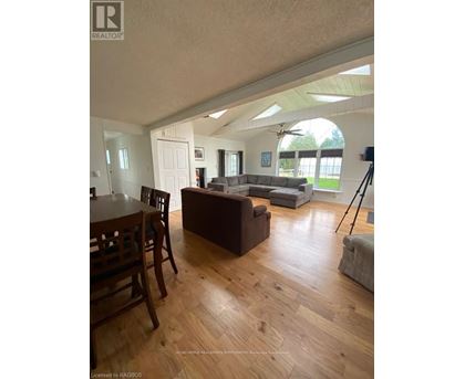 A living room with a brown couch and a wooden dining table.