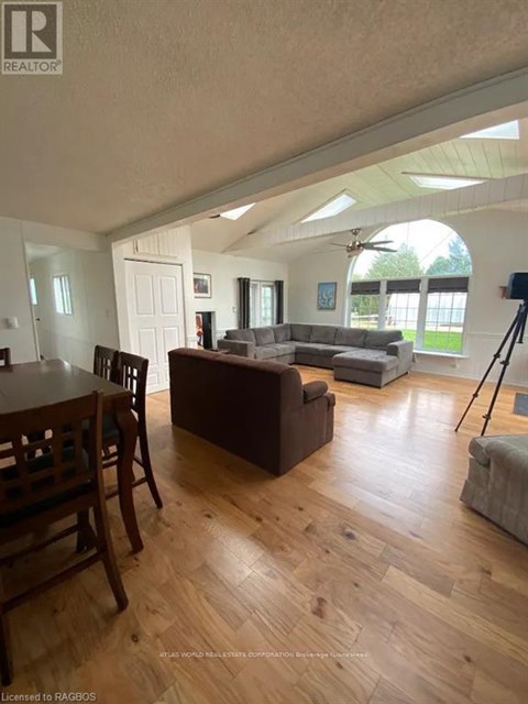 A living room with a brown couch and a wooden dining table.