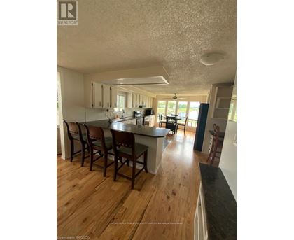 A kitchen with wooden floors and white walls.