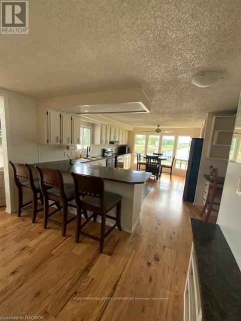 A kitchen with wooden floors and white walls.