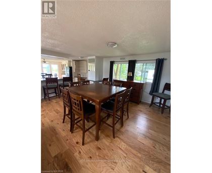 A dining room with a wooden table and chairs.