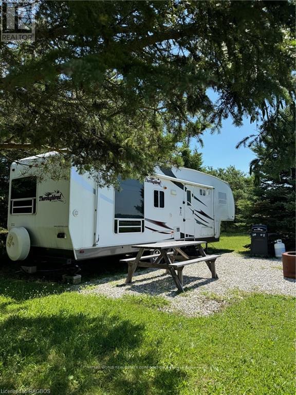 A white RV is parked in a grassy area.