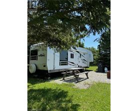 A white RV is parked in a grassy area.