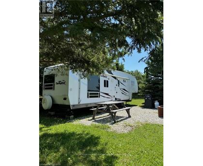 A white RV is parked in a grassy area.