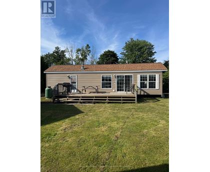 A house with a brown roof and a deck in front.