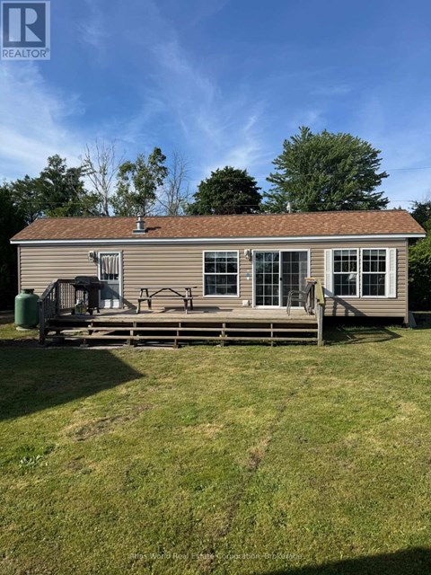 A house with a brown roof and a deck in front.