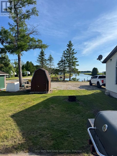 A backyard with a grill and a shed.