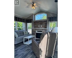 A living room with a grey couch, a white coffee table, and a beige armchair.