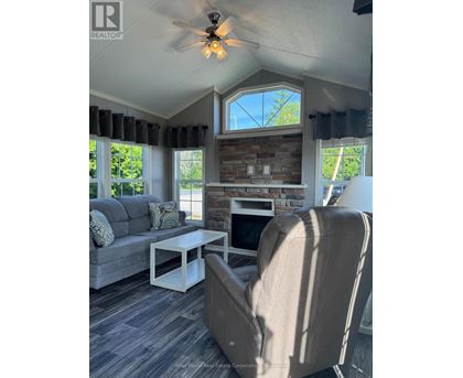 A living room with a grey couch, a white coffee table, and a beige armchair.