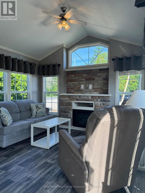 A living room with a grey couch, a white coffee table, and a beige armchair.