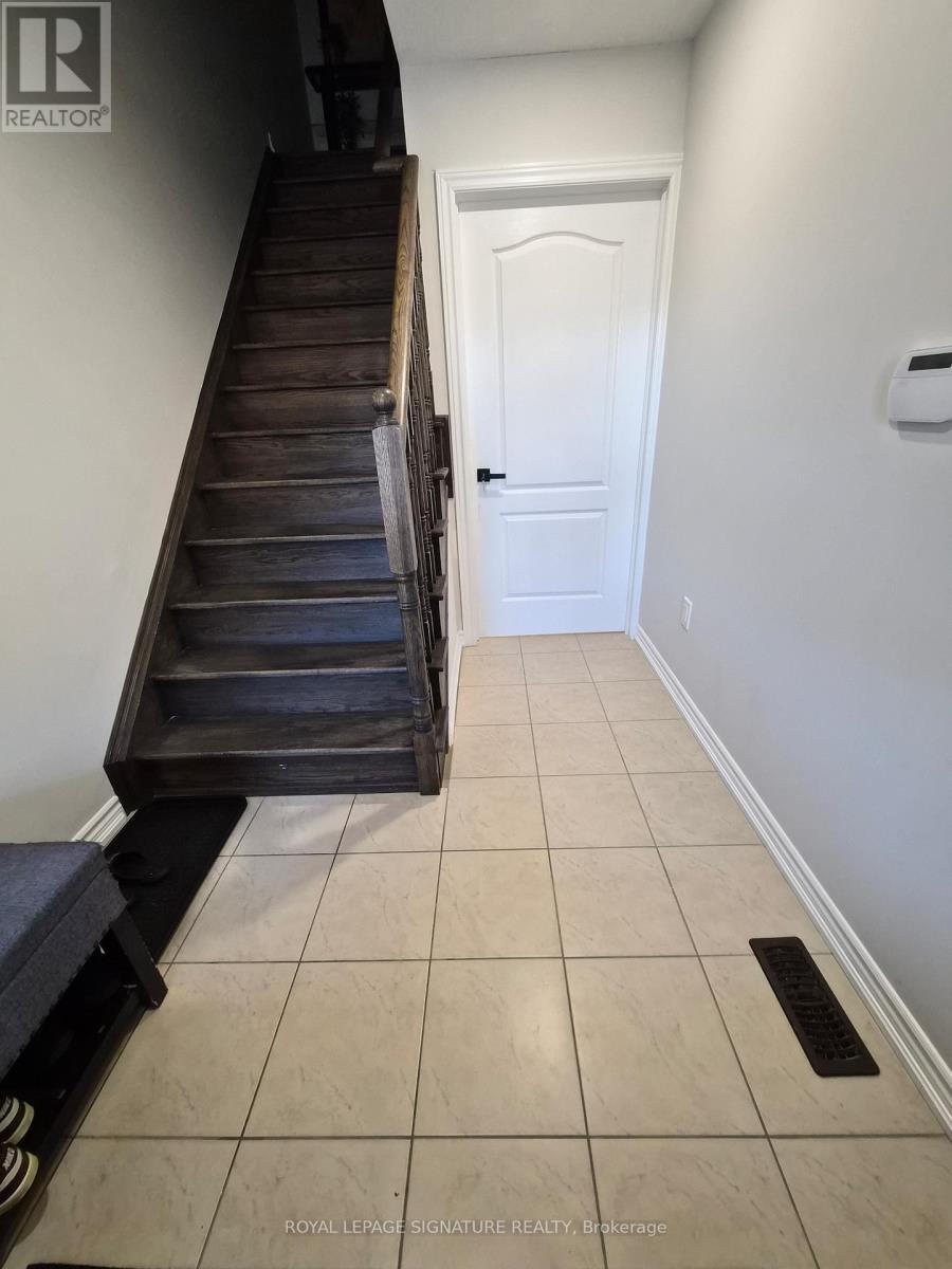 A hallway with a white door and a wooden staircase.