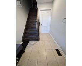 A hallway with a white door and a wooden staircase.