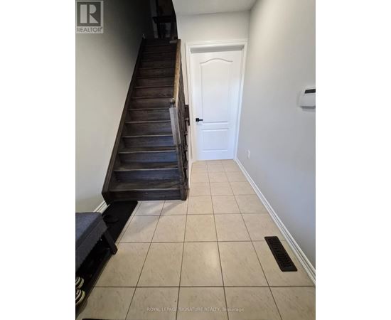 A hallway with a white door and a wooden staircase.