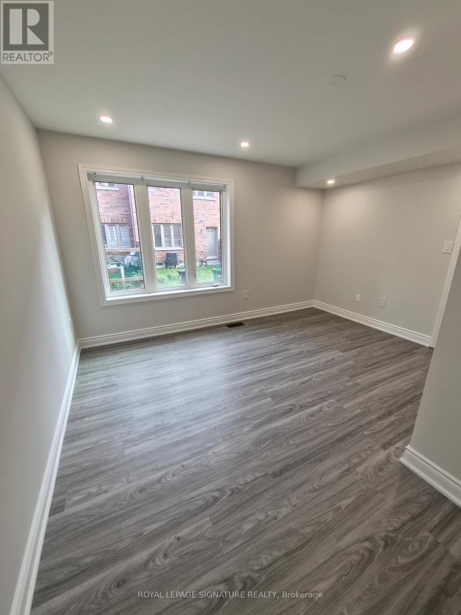 A room with a window and wooden flooring.