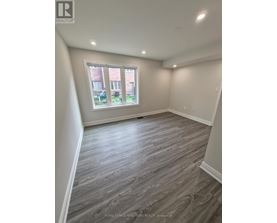 A room with a window and wooden flooring.
