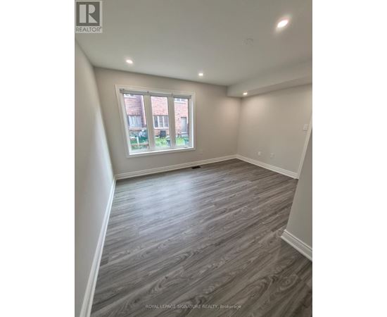A room with a window and wooden flooring.