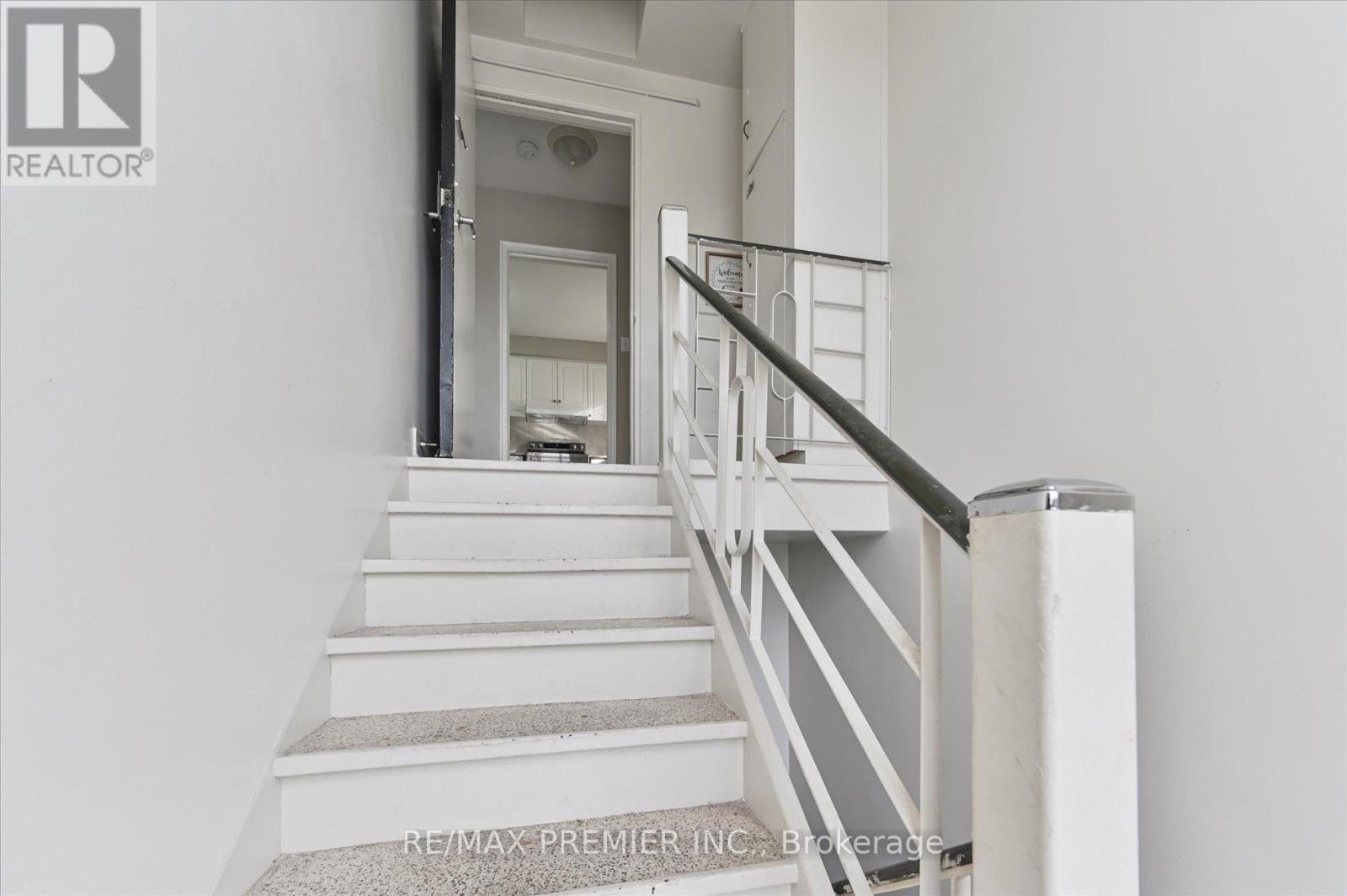 A staircase with a metal railing and a carpeted runner.
