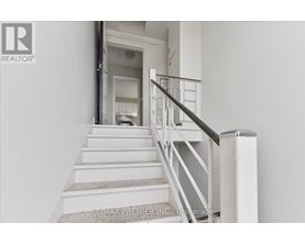 A staircase with a metal railing and a carpeted runner.