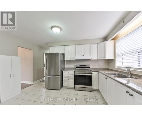 A kitchen with white cabinets and a stainless steel refrigerator.
